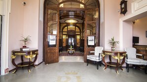 A grand hallway with ornate woodwork, a chandelier, and a large crown symbol on the floor. - Rubezahl Marienbad Luxury Historical Castle Hotel & Golf - Castle Hotel Collection (Marianske Lazne)