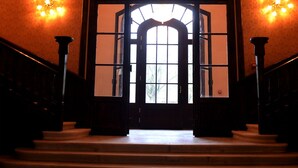 A grand entrance with a large arched doorway, a staircase leading up, and three stained glass windows above. - Rubezahl Marienbad Luxury Historical Castle Hotel & Golf - Castle Hotel Collection (Marianske Lazne)