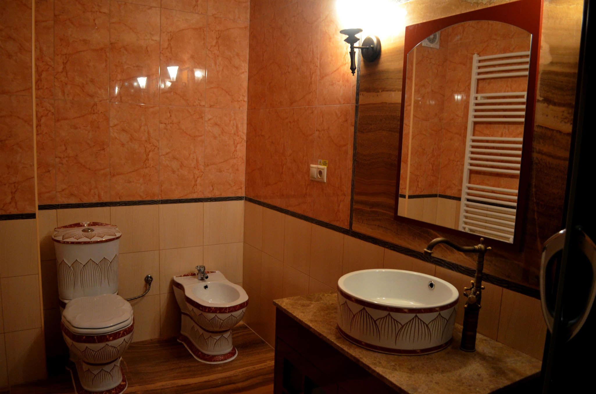 A bathroom with a toilet, bidet, and sink.