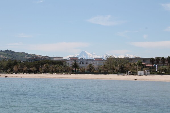 Una playa cerca, sillas reclinables de playa, sombrillas