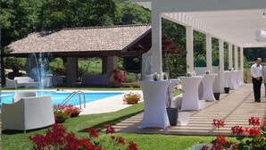 Een zwembadgedeelte met een pergola, buitengemeubilair en een berg op de achtergrond.