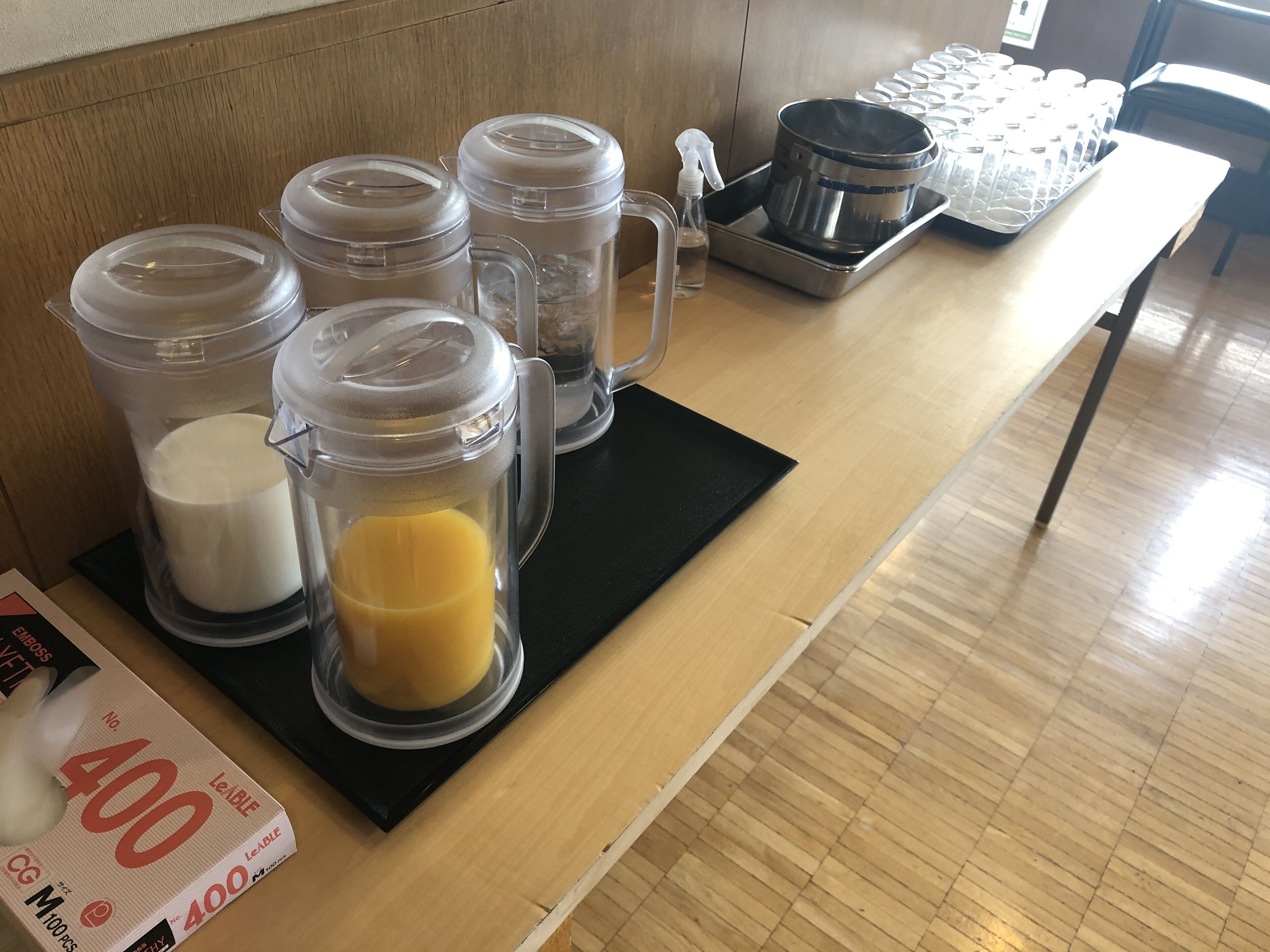 A kitchen counter with various containers, a spray bottle, and a tray of muffin tins.