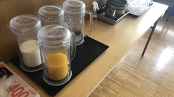 A kitchen counter with various containers, a spray bottle, and a tray of muffin tins.