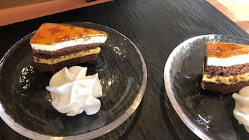 Two glass plates with slices of layered cake and whipped cream.