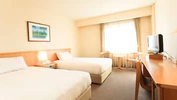 A hotel room with two beds, a desk, a chair, a television, and a window with curtains.