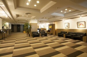 Un vestíbulo de hotel con mostrador de recepción, zona de estar y recepción.