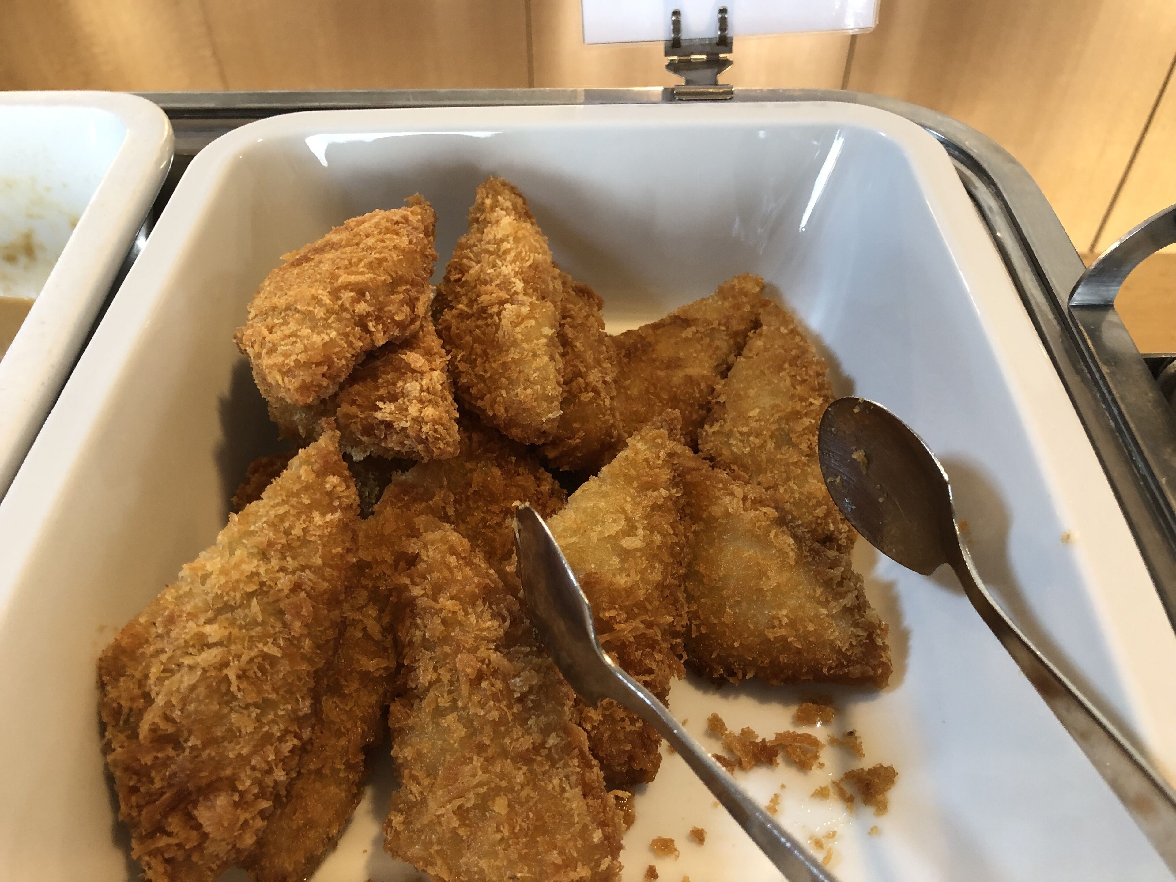 A tray of fried food items with a spoon.