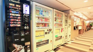 Een rij automaten in een hotelgang, met drankjes, snacks en een glimlach van de hotelbediening.