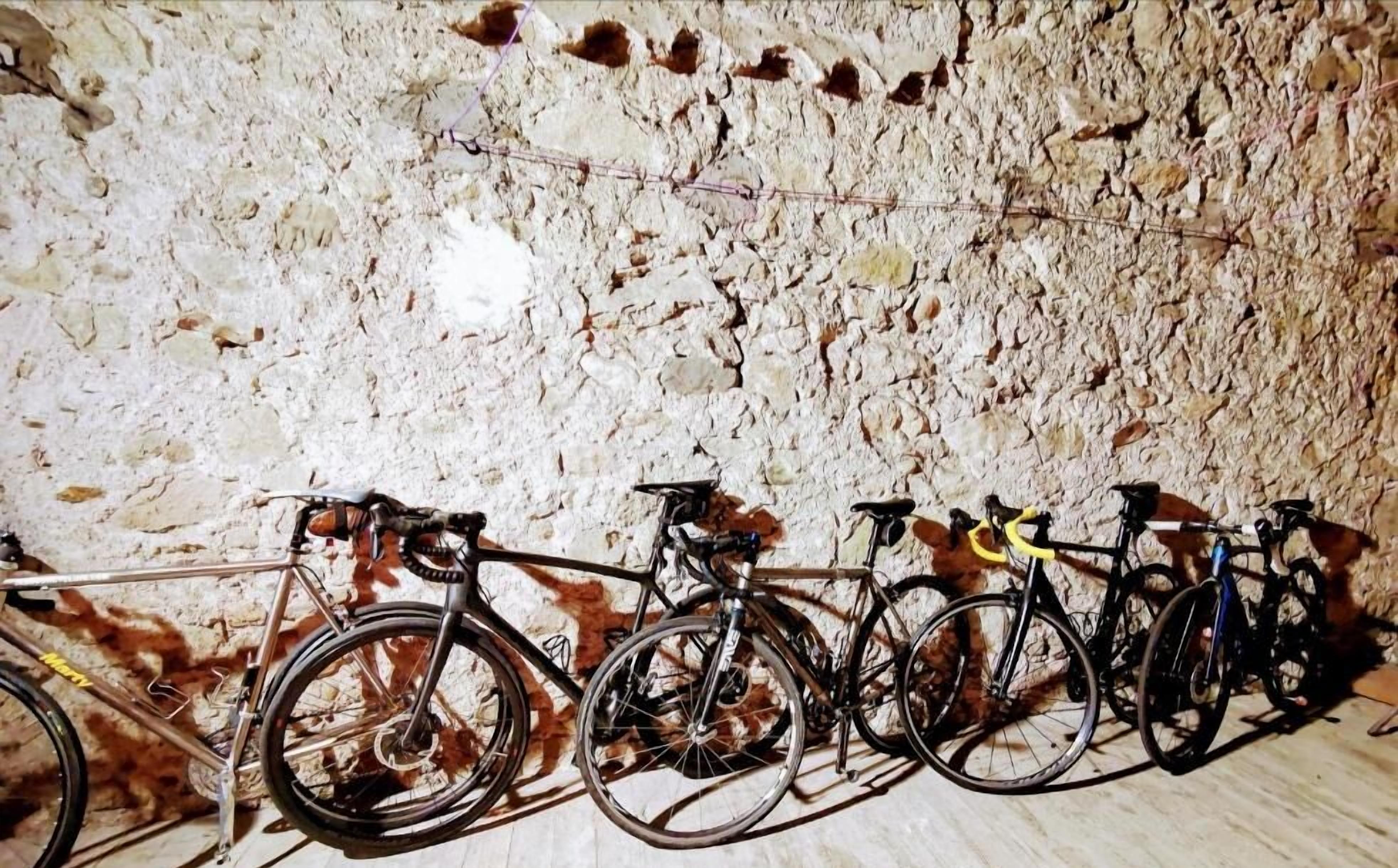 Bicycles parked against a textured wall.