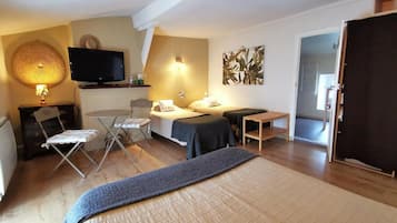 Une chambre d’hôtel confortable, équipée d’un lit, d’un bureau, d’une chaise, d’une télévision et d’une lampe fixée au mur.