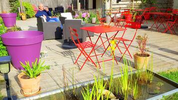 A patio with outdoor furniture, a small pond, and potted plants.