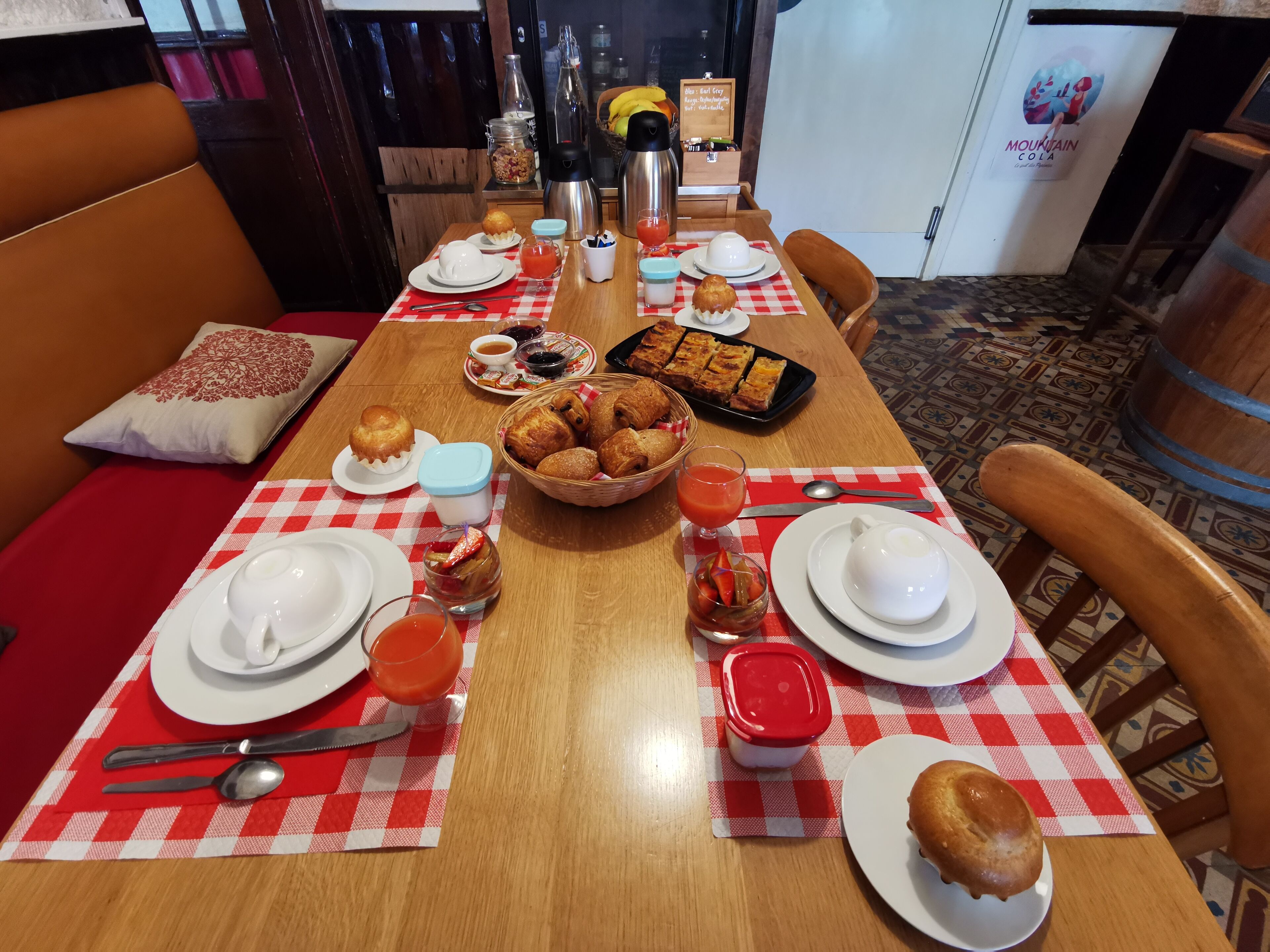 Una tavola imbandita per la colazione, con piatti, tazze, dolci e bevande.