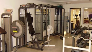 Un gimnasio con diversos equipos de ejercicio, incluyendo máquinas de pesas y pesas libres.