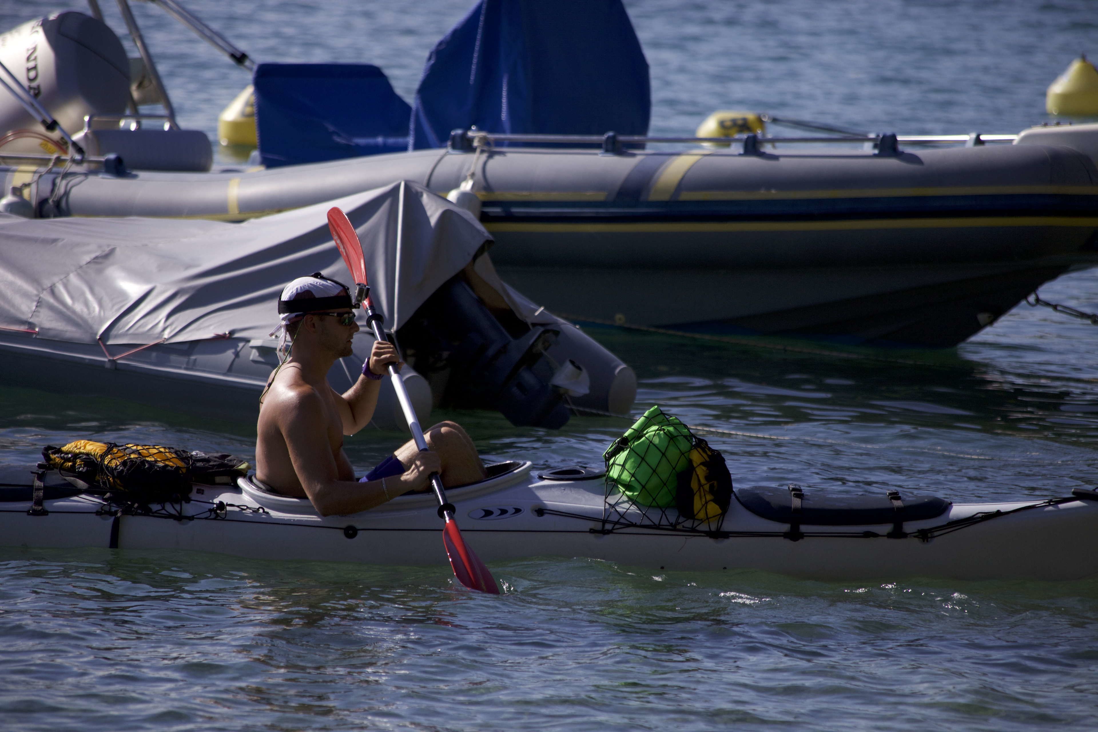 A person kayaking on a calm body of water.