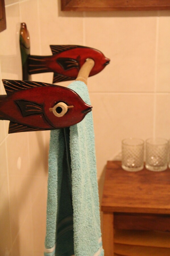 A towel hanging on a rack with a fish-shaped towel holder. - Praia Inhame Eco-Lodge (Malanza)