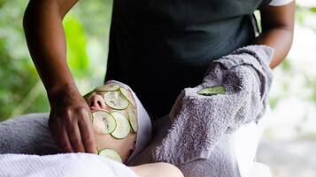 Une personne qui reçoit un soin du visage à base de rondelles de concombre.