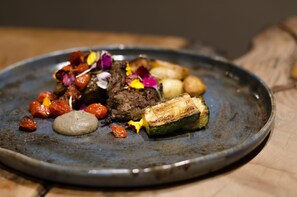 A plate of food with various items including meat, potatoes, and vegetables. - Summerfields Rose Retreat & Spa (Mbombela)