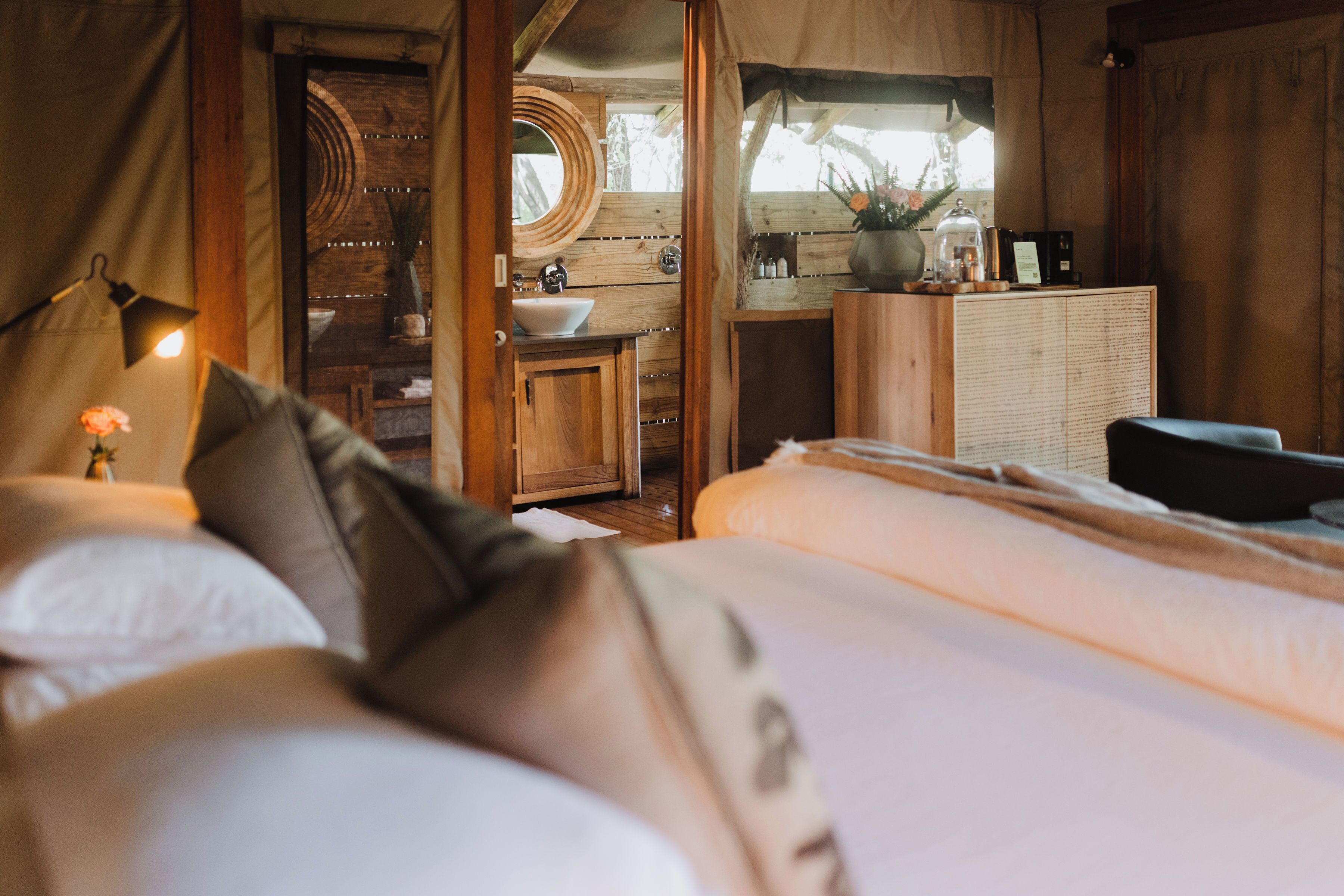 A bedroom with a large bed, wooden headboard, and a bedside table with a lamp.