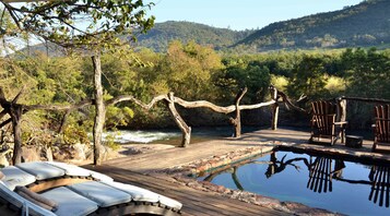 室外游泳池，池畔遮阳伞，日光浴躺椅