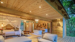 Una cabaña de madera con un dormitorio, un baño y una sala de estar con sofá y mesa.