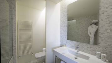 A bathroom with a white sink, a mirror, and a toilet.
