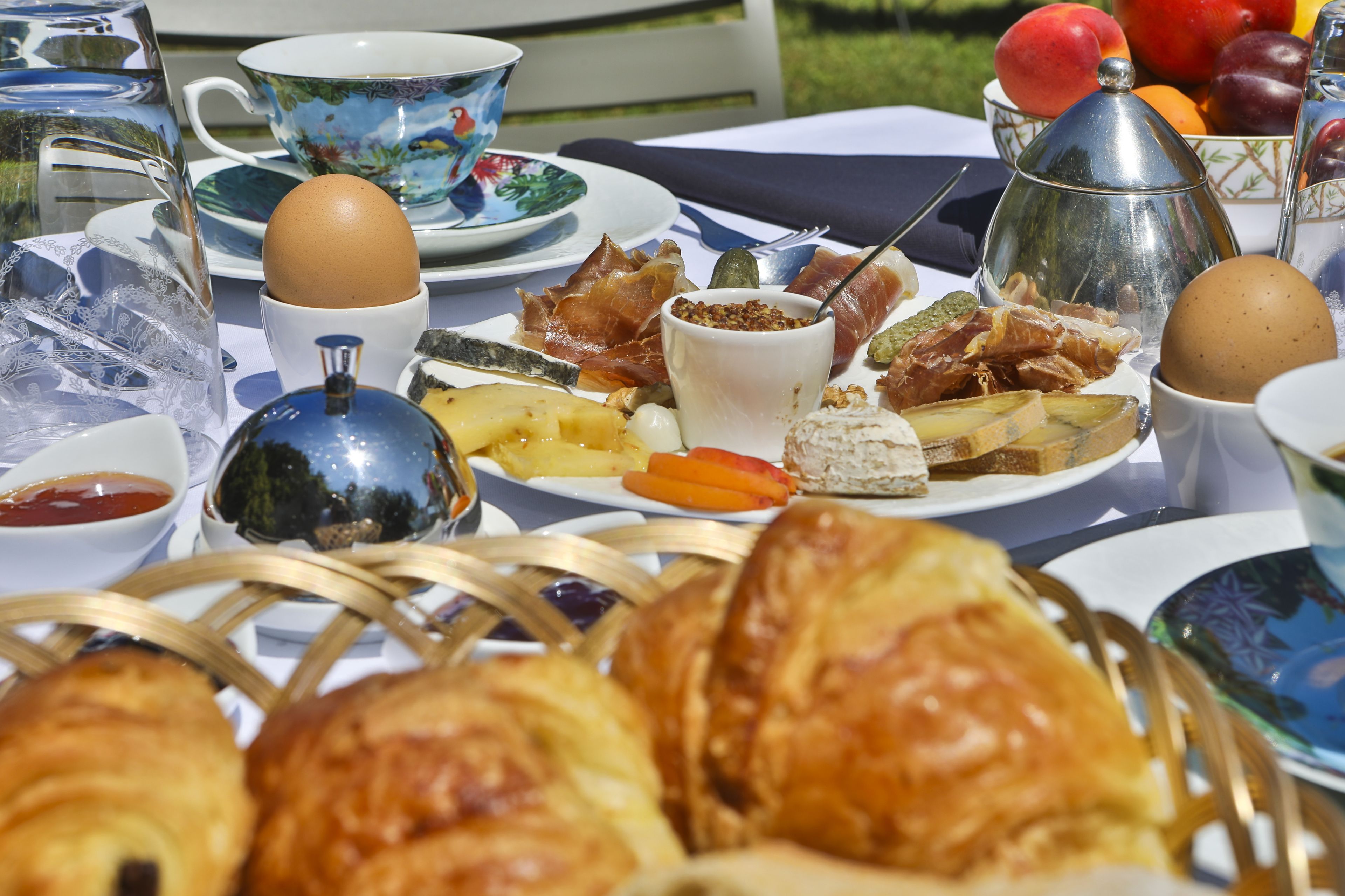 Una mesa dispuesta con diversos alimentos para el desayuno, como huevos, pasteles y frutas.