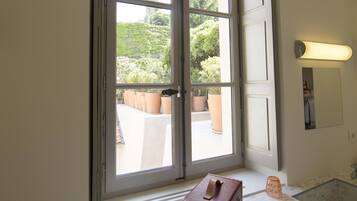 A bathroom with a large window, a mirror, and a towel box.