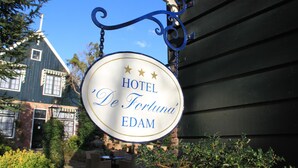 Placa do 'Hotel De Fortuna', com design clássico e três estrelas.