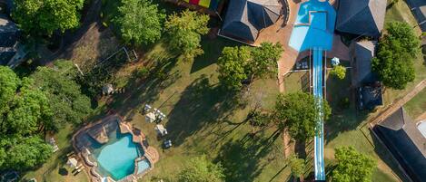 Vista aérea de una zona residencial con piscina, tobogán y un área de juegos colorida.