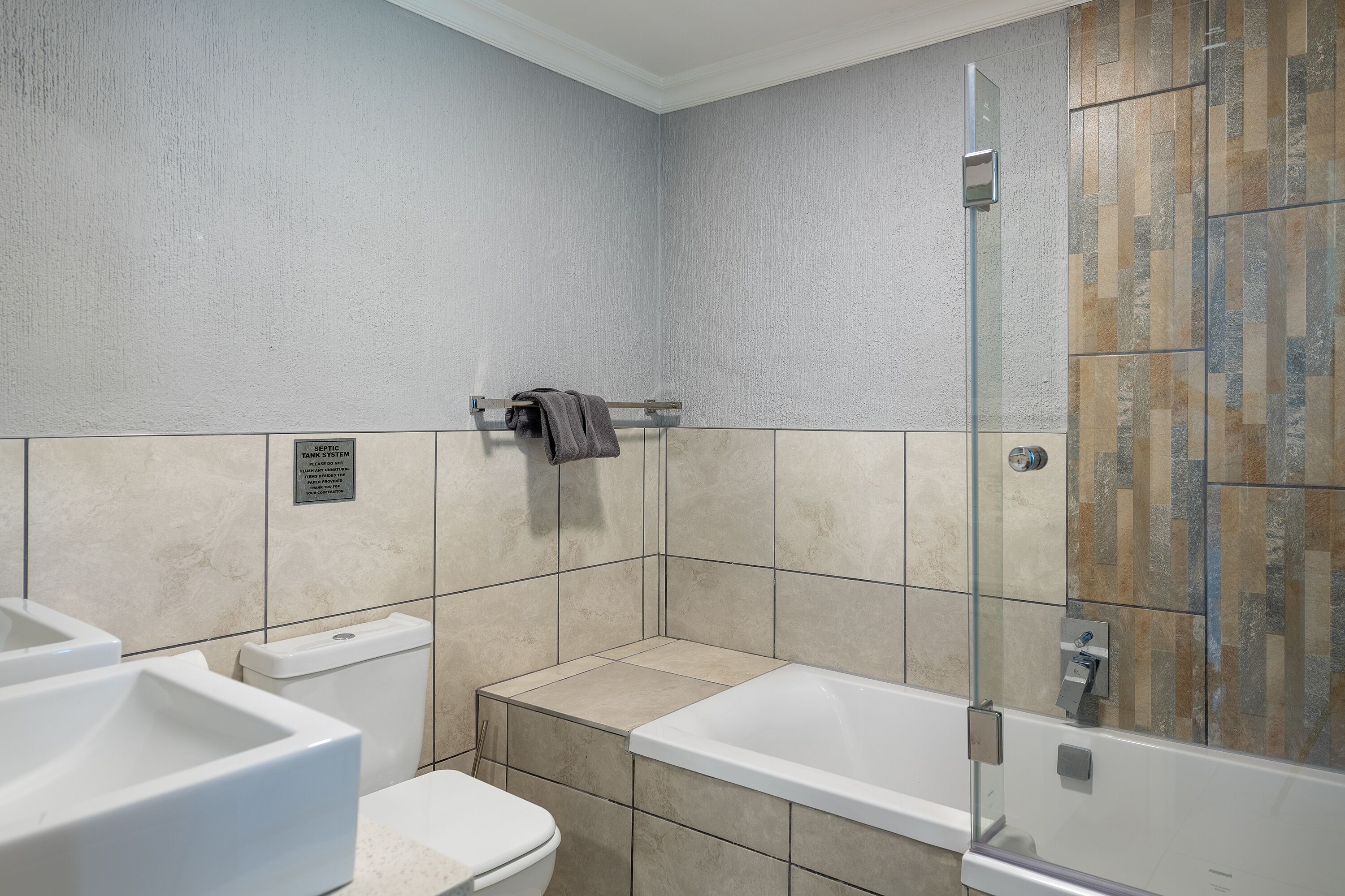 A bathroom with a bathtub, toilet, and sink.