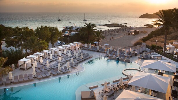 A resort with a swimming pool, sun loungers, umbrellas, and a beach area with a view of the sea. - Insotel Tarida Beach Resort & SPA - All inclusive (Sant Josep de sa Talaia)