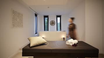 Relax in a serene space with a massage table, pillow, and towels, and enjoy a view of the outdoors.