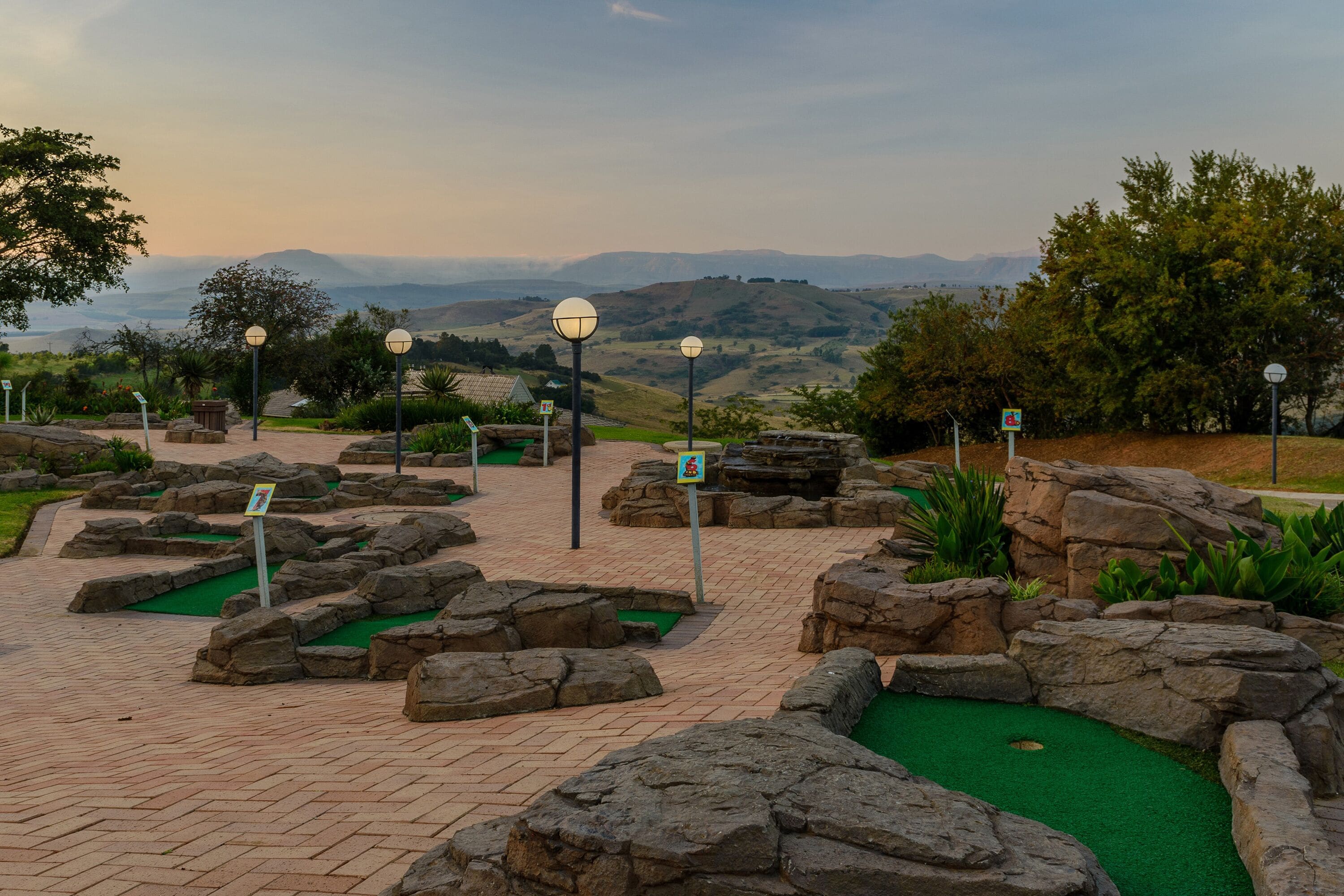 A miniature golf course with rock obstacles and green artificial turf.