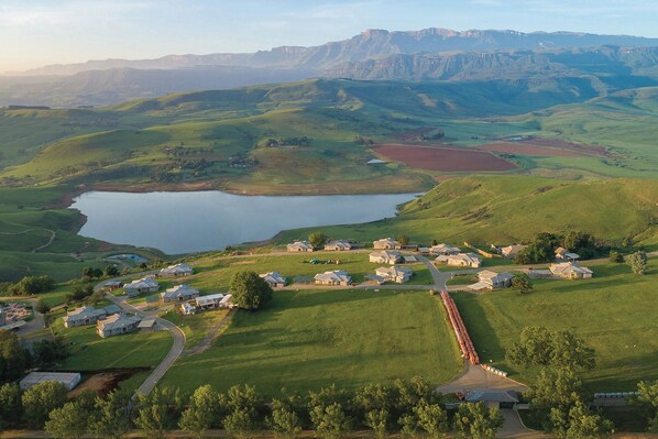 Zona residencial con casas, un lago y colinas onduladas al fondo.