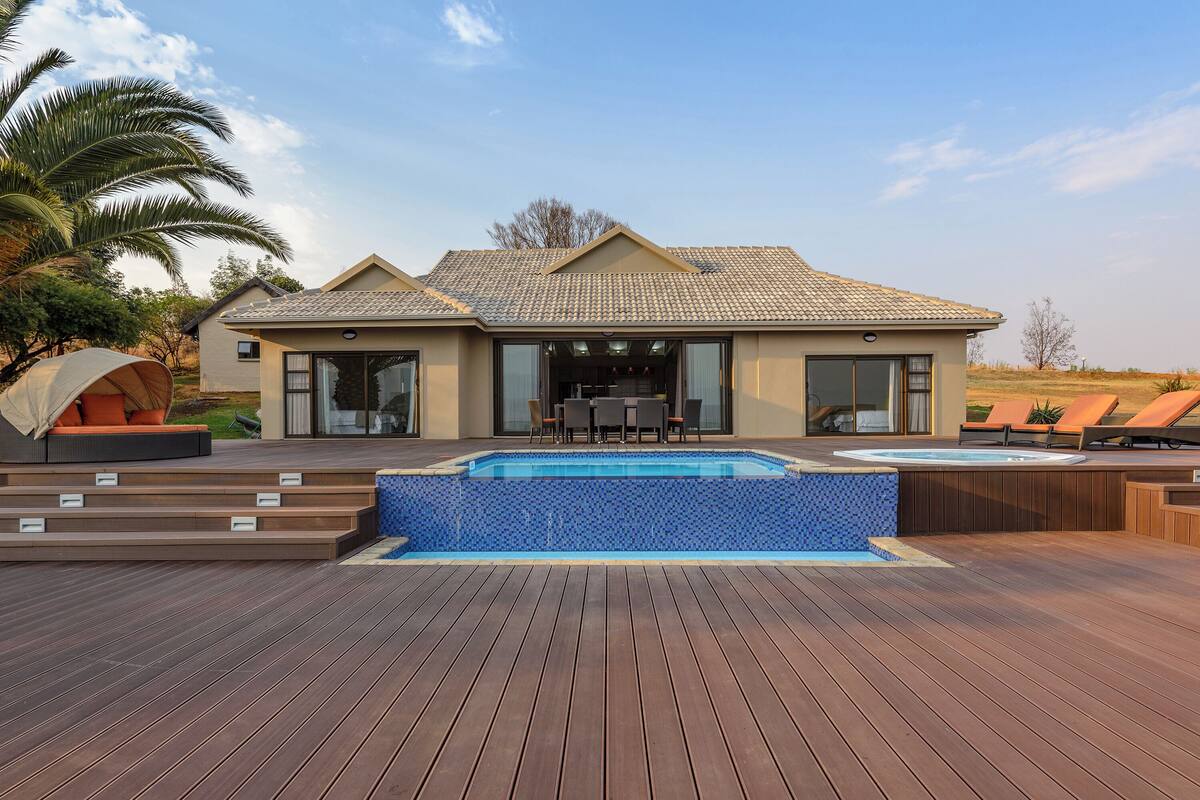 Une maison moderne dotée d’une piscine, d’un espace salon extérieur et d’un patio.