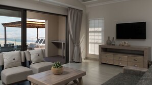 Una sala de estar moderna con balcón, televisor de pantalla plana y mesa de centro de madera.
