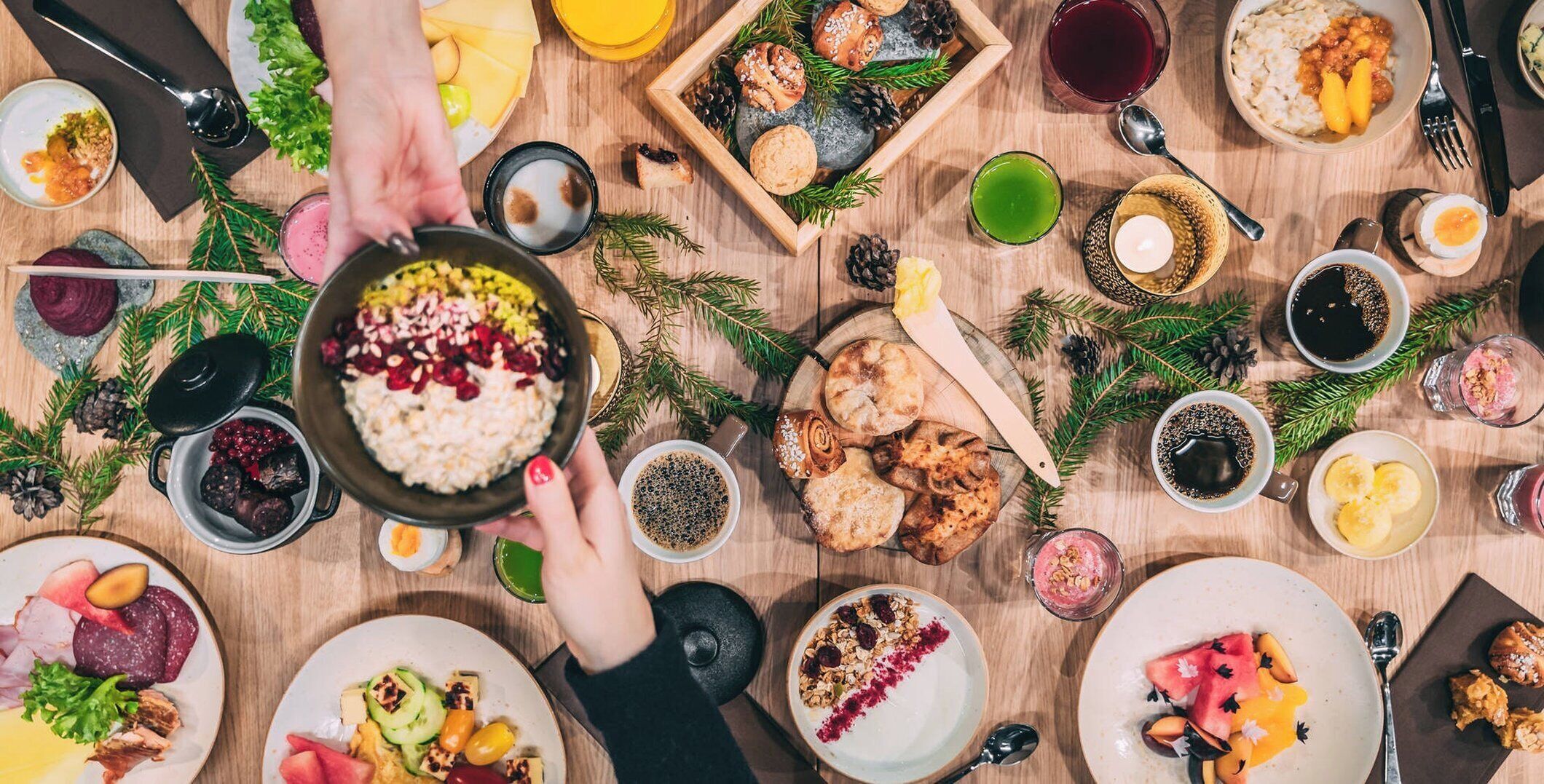Una comida festiva con diversos platos, bebidas y una mesa de madera.
