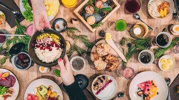 Una comida festiva con diversos platos, bebidas y una mesa de madera.