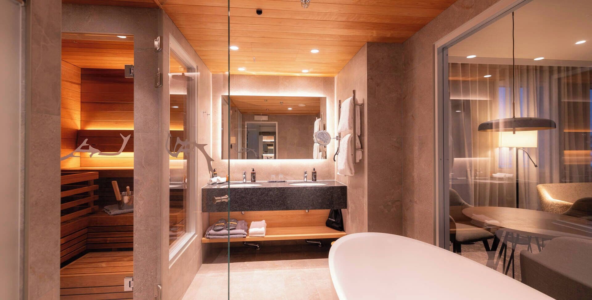 A modern bathroom with a wooden vanity, a large mirror, and a separate shower area.