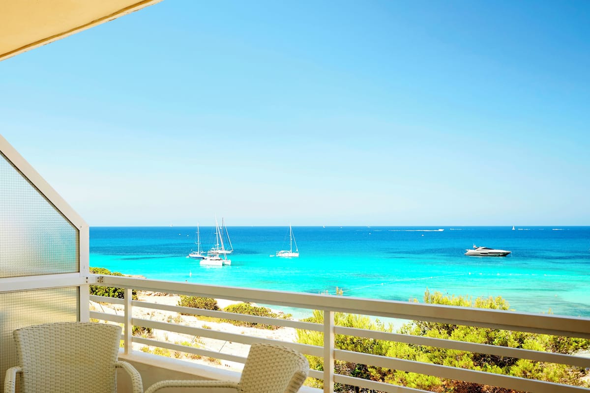A balcony with a view of the sea, featuring sailboats and a yacht.