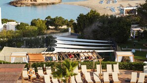 Un complexe hôtelier doté d’une piscine, de chaises longues et offrant une vue sur la mer.