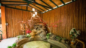 A spa area with a hot tub, wooden walls, and decorative plants. - Vartika Adventure Retreatic Resort (Prachuap Khiri Khan)