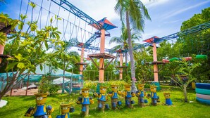 A rope bridge, palm trees, and a series of planter sculptures. - Vartika Adventure Retreatic Resort (Prachuap Khiri Khan)