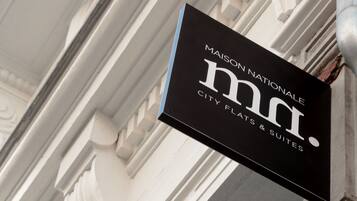 Une enseigne pour l'établissement Maison Nationale City Flats & Suites.
