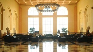 A spacious lobby with a polished marble floor, large arched windows, and a central chandelier. - Djerba Castille Hotel (Aghir)