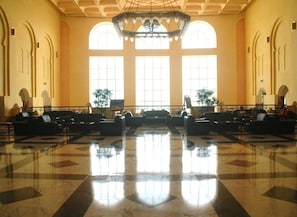A spacious lobby with a polished marble floor, large arched windows, and a central chandelier. - Djerba Castille Hotel (Aghir)