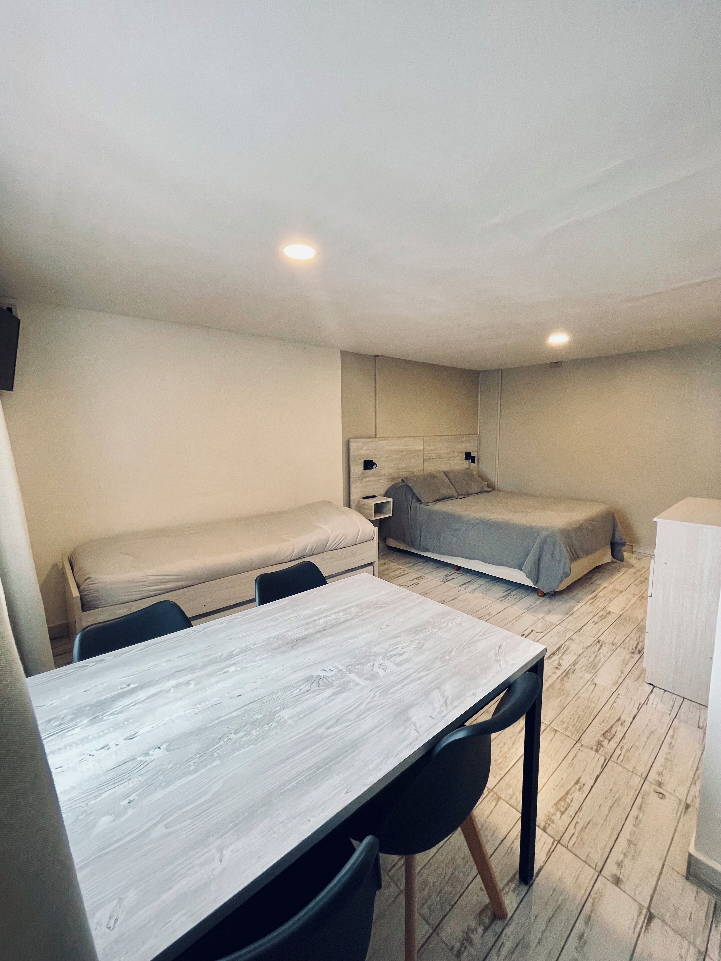 Une petite chambre comprenant un lit, un petit bureau et une chaise.