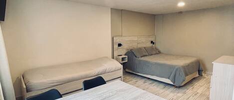 Une petite chambre comprenant un lit, un petit bureau et une chaise.