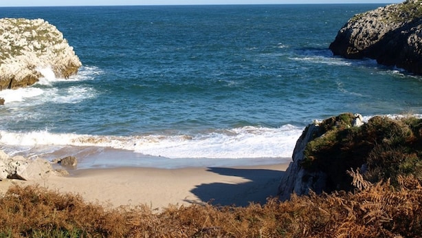 A coastal landscape with a sandy beach, rocky outcrops, and the sea. - Hotel Rural Ovio (Llanes)