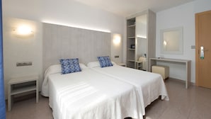 A modern bedroom with a large bed, bedside tables, a wardrobe, and a desk with a mirror. - Hostal Roca (Sant Antoni de Portmany)